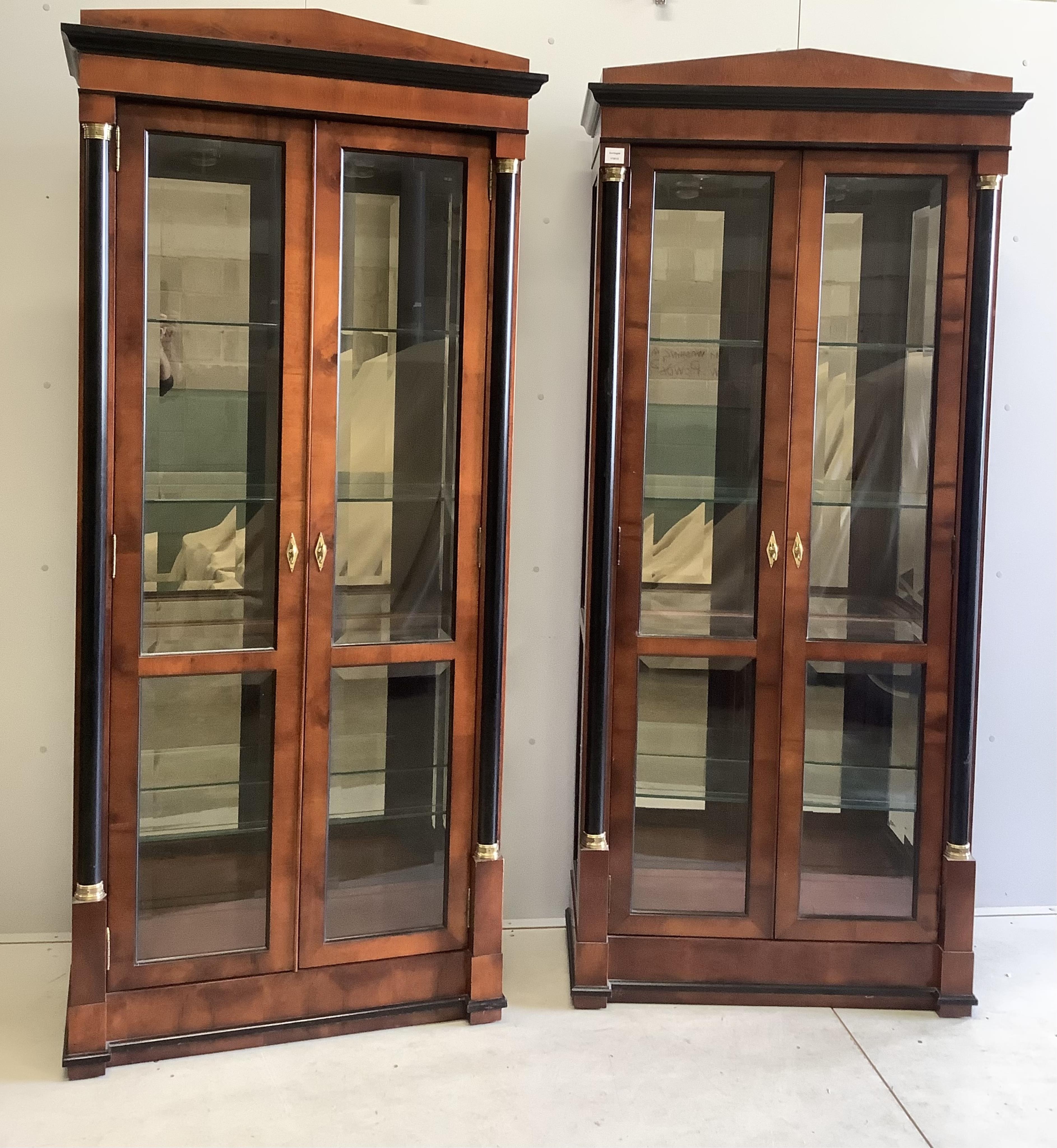 A pair of French Empire style mahogany and ebonised two door display cabinets, width 92cm, depth 42cm, height 210cm. Condition - good